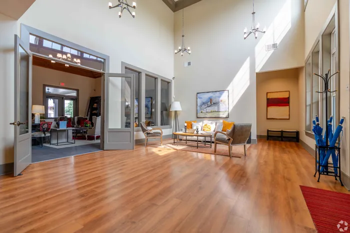 Bright and spacious lounge with wooden flooring, stylish seating, and contemporary decor.
