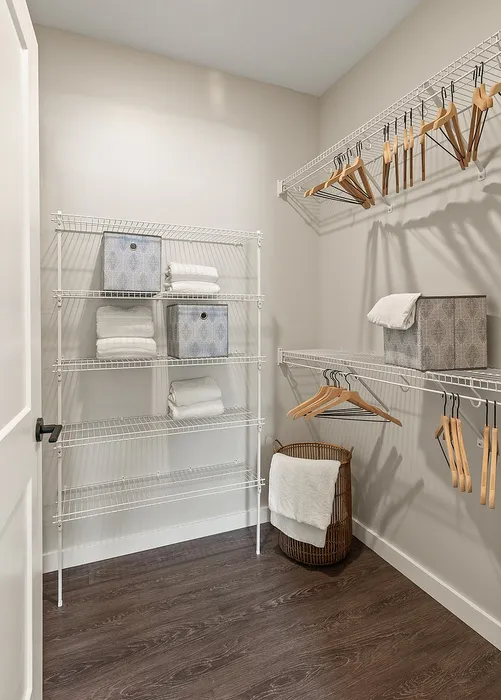 Elegant walk-in closet with sleek wire shelving, abundant storage, and wooden hangers, perfect for organized living.