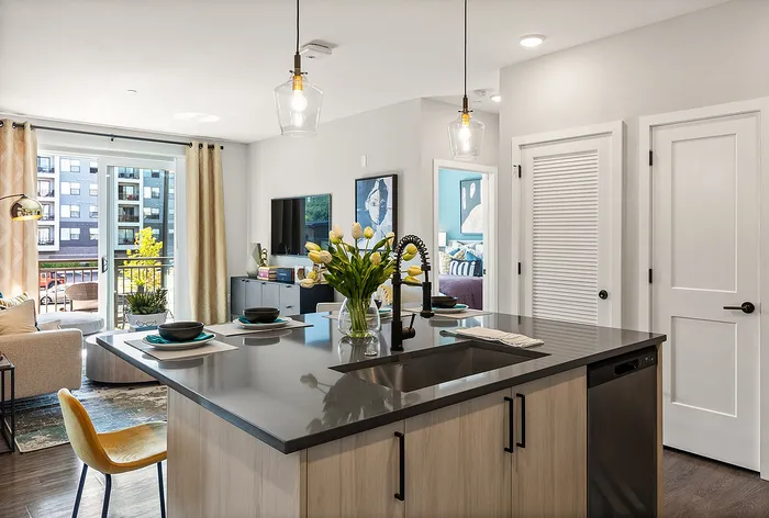 Chic apartment with modern kitchen island, open living space, and floor-to-ceiling windows offering abundant natural light.