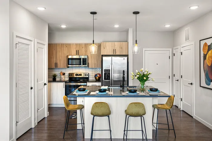 Elegant modern kitchen with sleek cabinetry, stainless steel appliances, and a stylish island with seating for three.