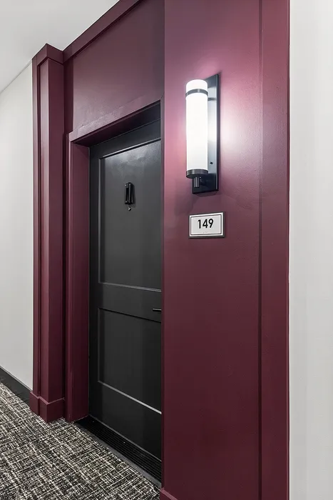 Elegant apartment entryway with stylish maroon accents and modern lighting at door number 149.