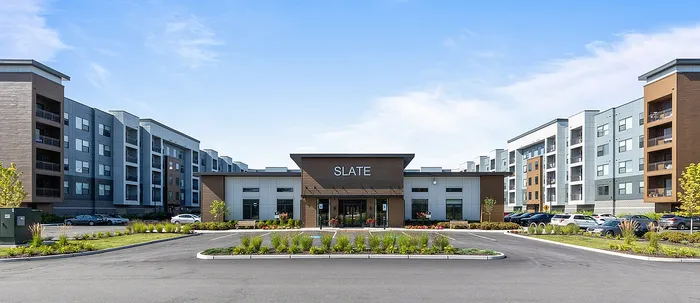 Contemporary apartment complex featuring sleek architecture, lush landscaping, and ample parking, offering a modern living experience.