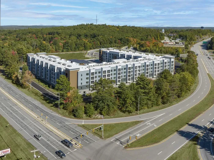 Modern apartment building surrounded by lush greenery, offering scenic tranquility and contemporary living.