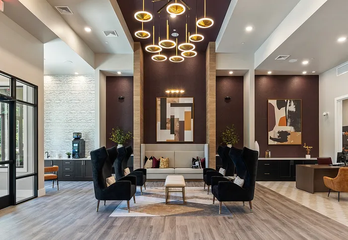 Elegant lobby with modern seating, artistic lighting, and contemporary artwork, exuding a warm and inviting ambiance.
