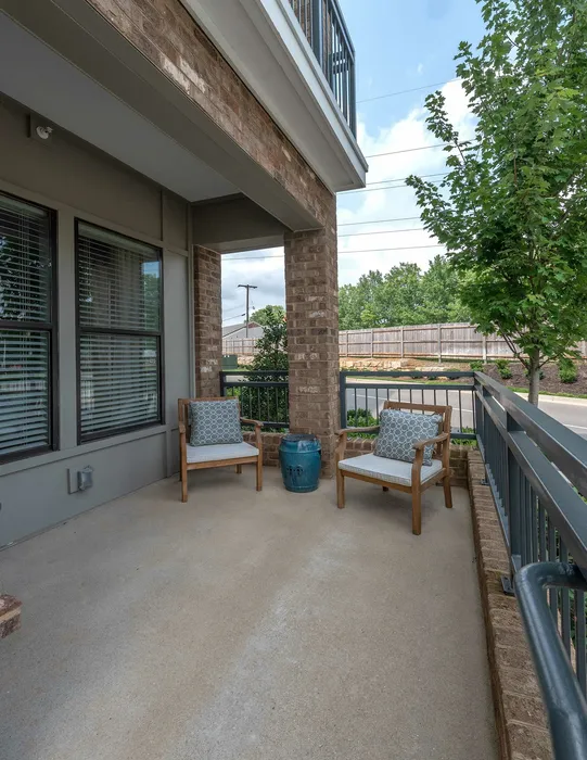 Charming outdoor patio with cozy seating and lush greenery, perfect for relaxation and outdoor enjoyment.