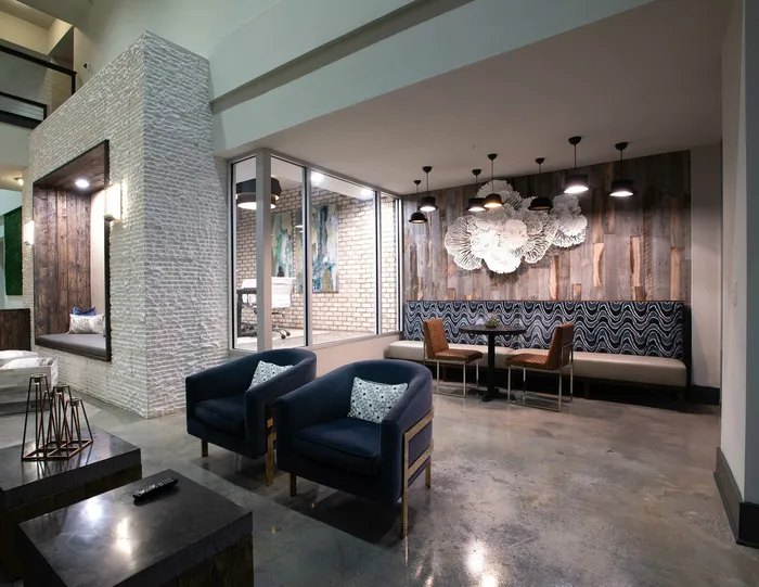 Modern apartment lounge featuring chic furniture, cozy seating, and stylish wall art with ambient lighting.