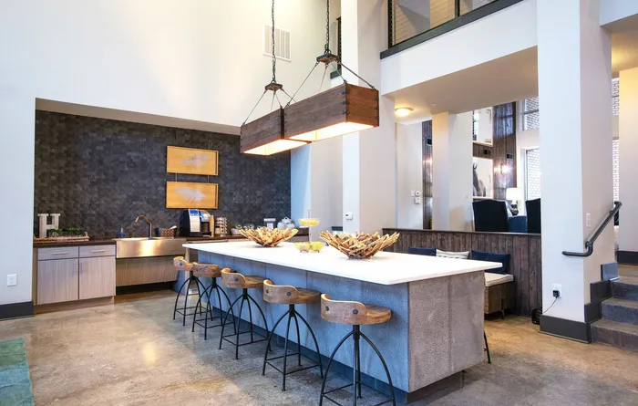 Modern open-concept kitchen with elegant lighting, cozy seating area, and industrial chic design. Perfect for entertaining.