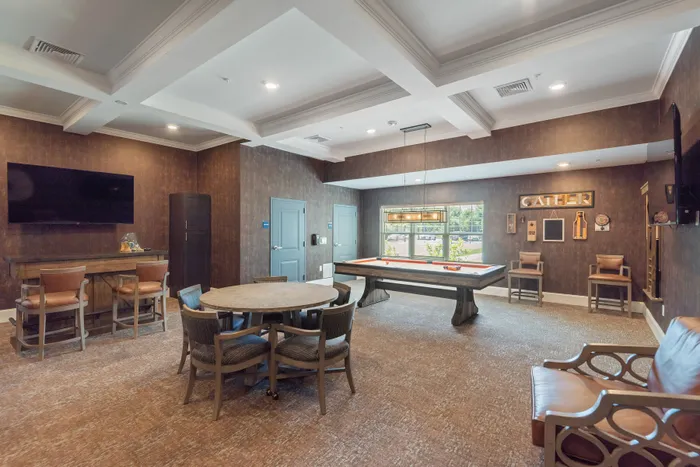 Elegant game room with stylish seating, pool table, and warm lighting, perfect for social gatherings.