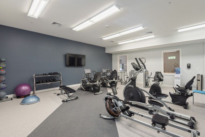 Modern fitness center with exercise machines, free weights, and yoga equipment, providing a vibrant workout space.