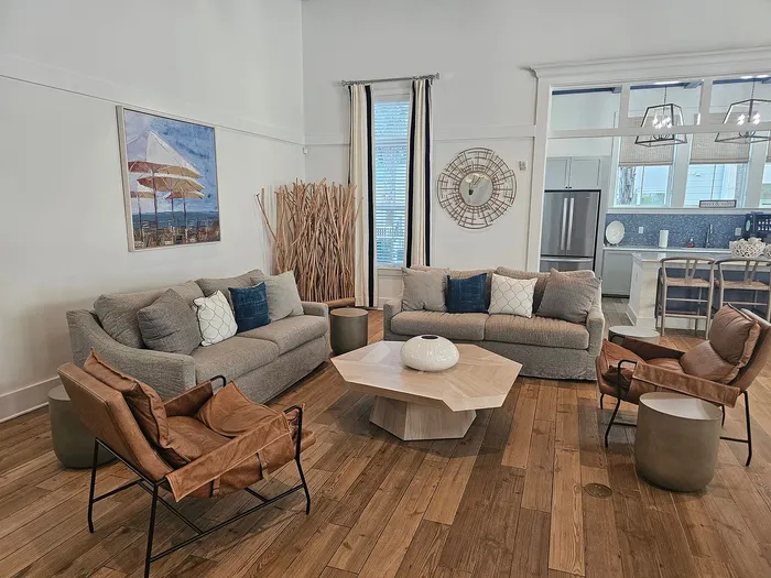 Inviting open-concept living area with modern decor, stylish furniture, and a view into a sleek kitchen.