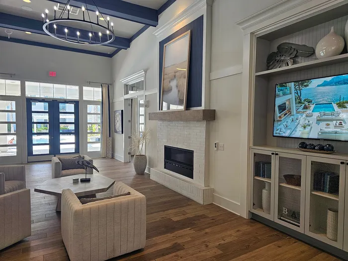 Luxurious living room with high ceilings, modern chandelier, cozy seating, and a stylish built-in fireplace, perfect for relaxation.
