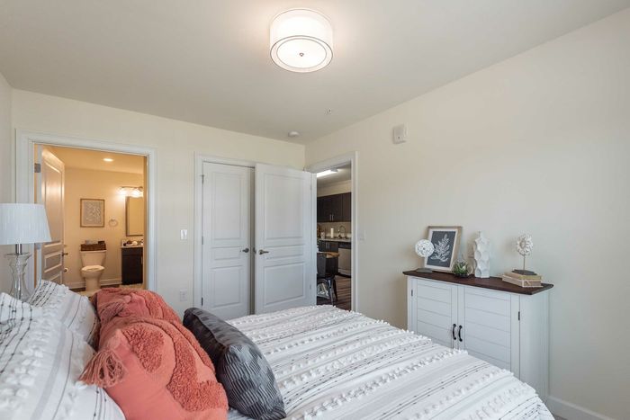 Inviting bedroom with plush bedding, ensuite bathroom, and sleek modern furniture.