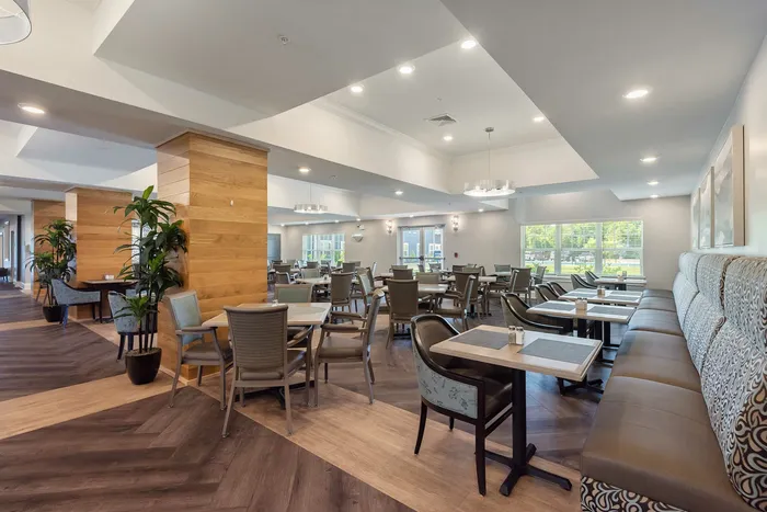 Elegant dining area with stylish seating, wooden accents, and large windows offering natural light. Perfect for gatherings and intimate meals.