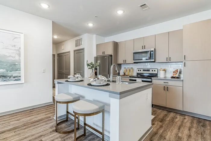 Modern kitchen with sleek cabinetry, stainless steel appliances, and a stylish island with seating, perfect for entertaining.