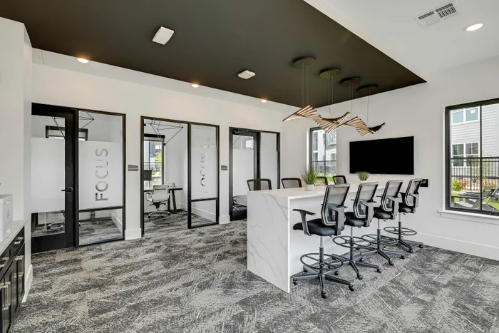 Modern office space with sleek design, featuring collaborative workstations, comfortable seating, and stylish lighting fixtures.