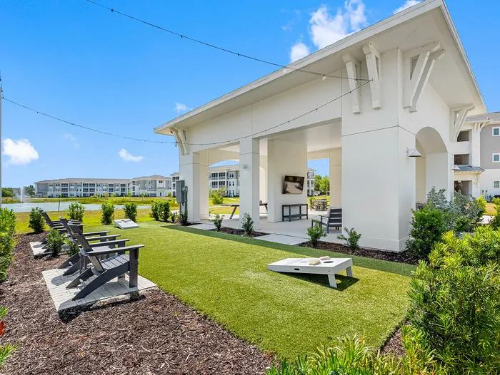 Charming outdoor space with stylish seating, green lawn, and entertainment area in a modern apartment complex.