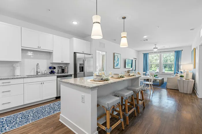 Bright open-concept kitchen and living area featuring modern decor, elegant countertops, and inviting seating with a view.