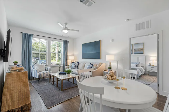 Inviting open living room with elegant decor, natural light, and direct access to a cozy bedroom.
