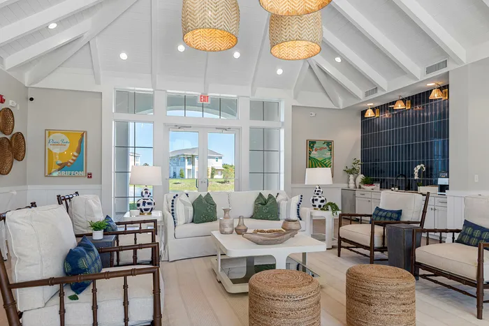 Bright, airy living room with vaulted ceilings, elegant wicker accents, and a stylish seating area, perfect for relaxation and entertaining.