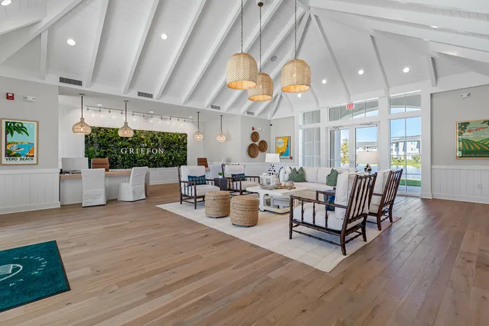 Elegant lobby with vaulted ceilings, natural lighting, and cozy seating areas in a luxurious apartment complex.