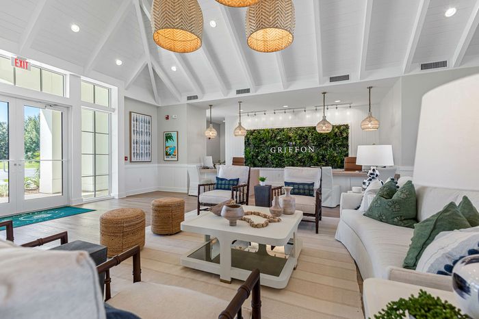 Inviting modern lobby at The Griffon, featuring cozy seating, elegant pendant lighting, and lush greenery for a welcoming atmosphere.