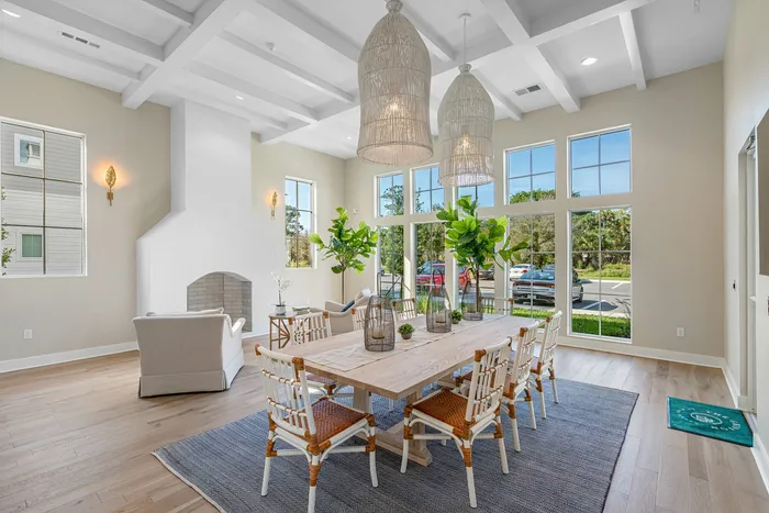 Bright and airy living room with high ceilings, elegant dining table, and large windows offering scenic views.