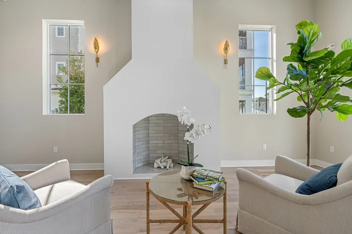 Elegant living room with a cozy fireplace, stylish armchairs, and a lush indoor plant, radiating warmth and charm.