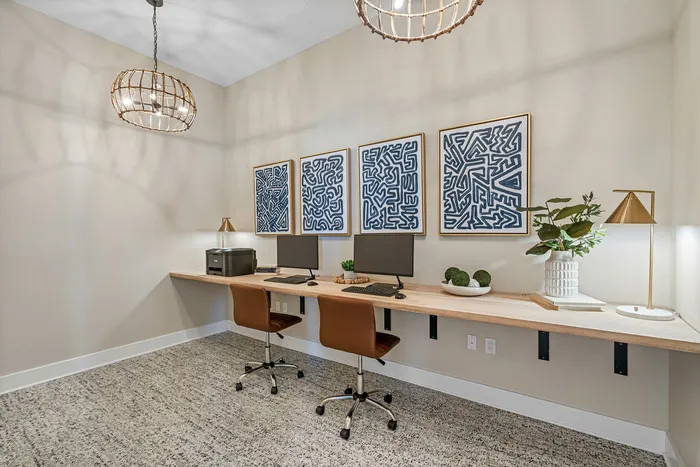 Modern home office with dual workstations, artistic wall decor, and contemporary lighting, ideal for productivity and style.