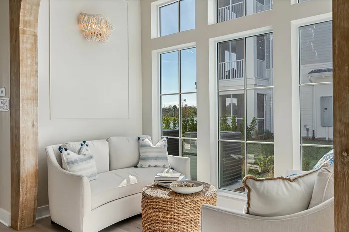 Bright and inviting seating area with chic furniture, large windows, and decorative lighting, perfect for relaxation and enjoying natural light.