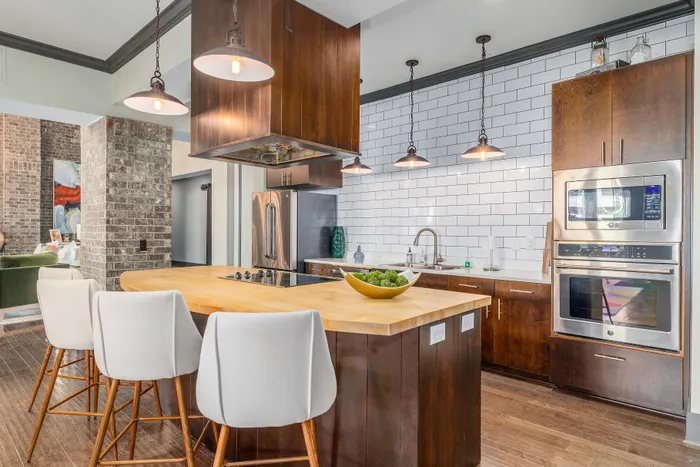 Modern kitchen with sleek wooden cabinets, high-end stainless steel appliances, and inviting bar seating.
