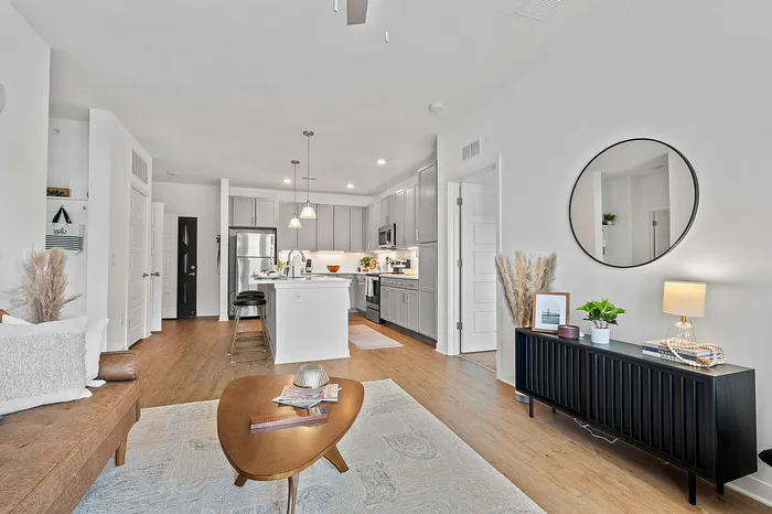Chic, modern open-concept living space with stylish kitchen, cozy seating, and elegant decor, featuring bright, natural lighting.