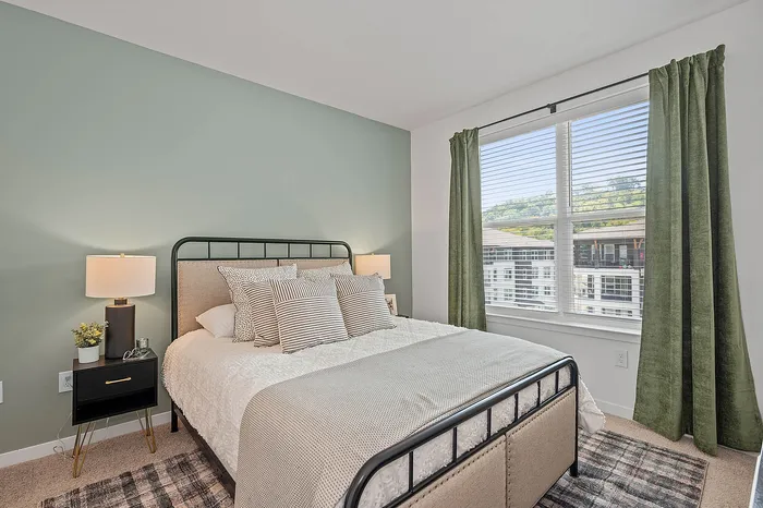 Bright and cozy bedroom with modern bed, elegant side table, and large window with a scenic view. Perfect for relaxation.