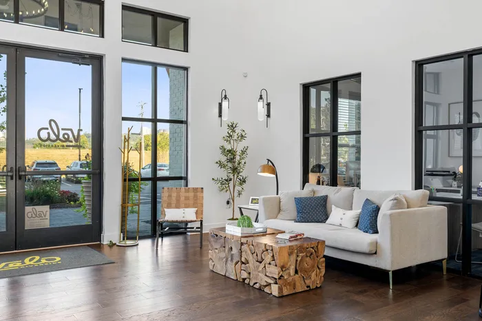 Inviting modern lounge area with elegant decor, featuring a plush sofa, unique wooden coffee table, and chic lighting.