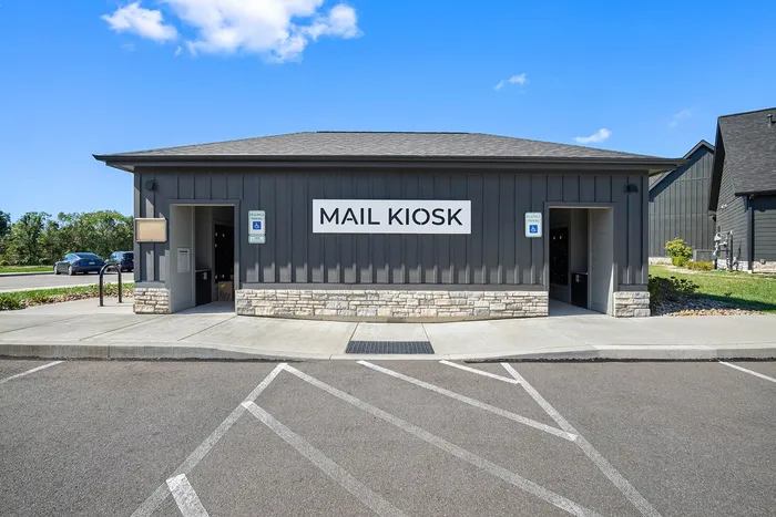 Modern mail kiosk with convenient access and dedicated parking in a picturesque community setting.