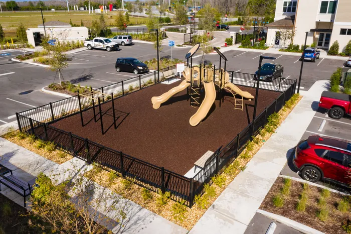 Inviting playground with multiple slides and climbing structures in a secure, landscaped area, perfect for family fun.