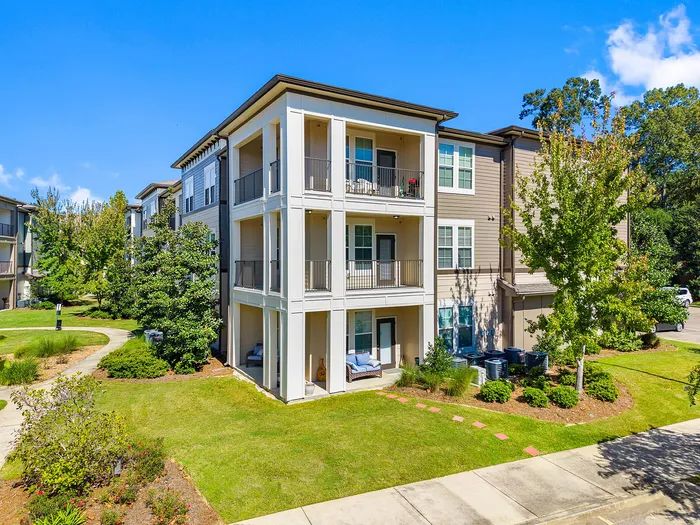 Elegant apartment building with spacious balconies and lush green surroundings, perfect for modern living.