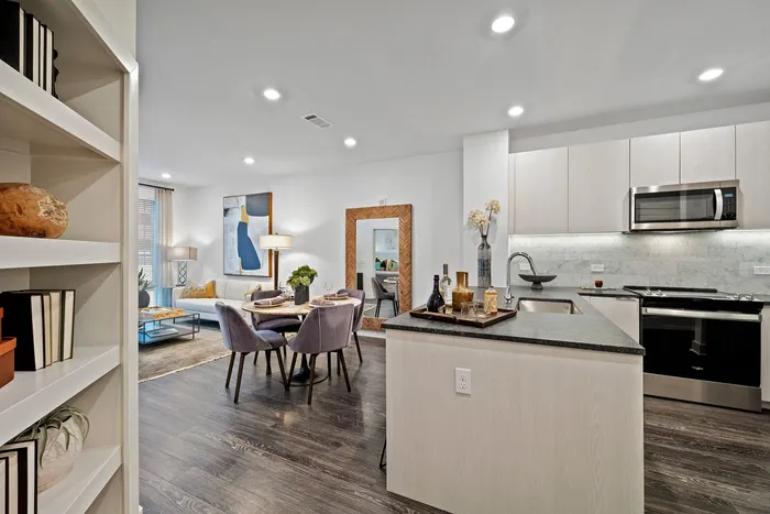 Modern open-concept living space with sleek kitchen, elegant dining area, and cozy living room designed for comfort and style.