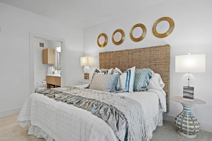 Elegant bedroom featuring a cozy bed with plush pillows, stylish wicker headboard, decorative wall plates, and ambient lighting, creating a serene retreat.