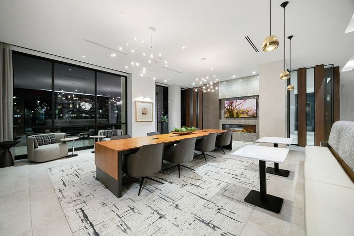 Elegant modern dining room with sleek furnishings, chic lighting, and expansive windows overlooking a beautiful cityscape.