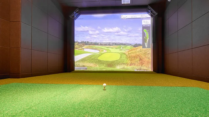 Luxurious indoor golf simulator room with surround sound and high-definition course display, ideal for golf enthusiasts seeking an immersive experience.