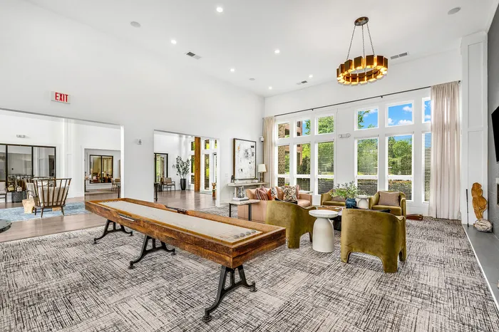 Spacious, well-lit communal living area with elegant seating, modern decor, and expansive windows for natural light.