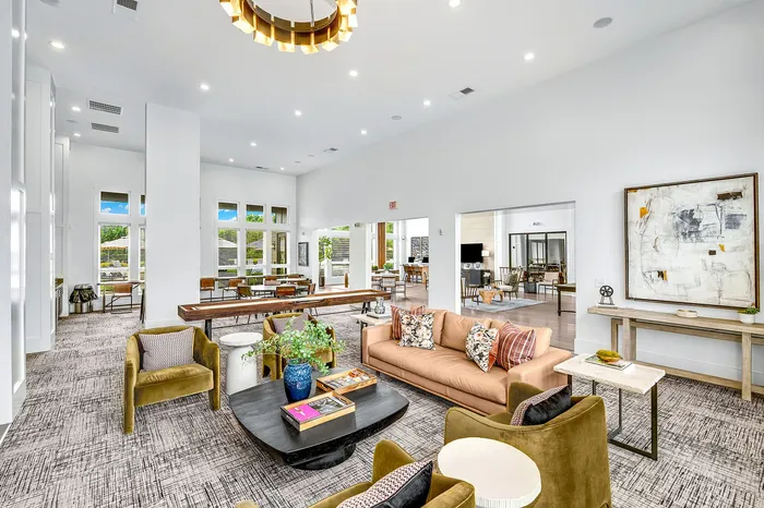 Bright and modern communal living space with stylish furnishings, featuring large windows, cozy seating areas, and elegant decor.