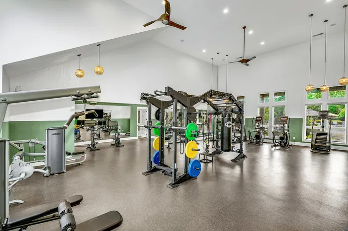 Spacious, modern gym with state-of-the-art equipment, natural lighting, and sleek interior design for a premium fitness experience.