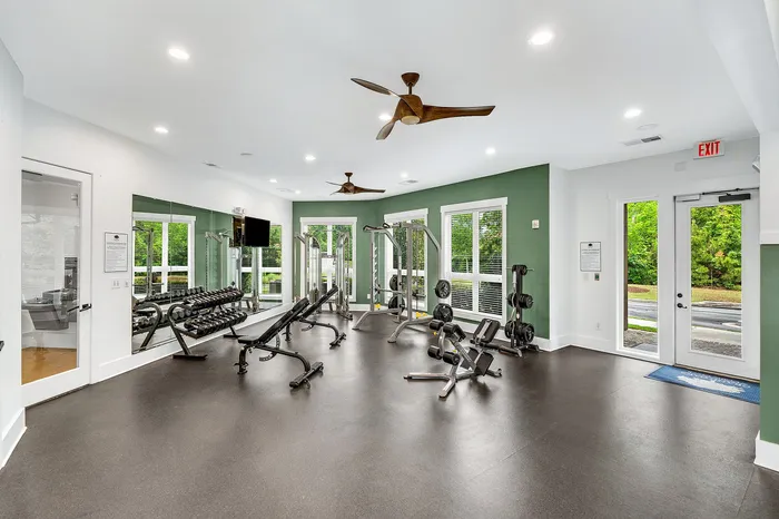 Modern fitness center with sleek equipment, large mirrors, and ample natural light, perfect for an invigorating workout.