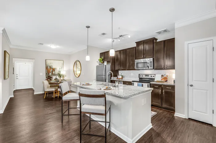 Modern open-concept kitchen design with sleek granite countertops, dark wood cabinets, and cozy dining area, perfect for entertaining.