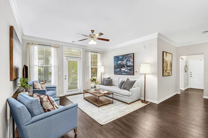 Elegant living room with cozy seating, tasteful artwork, and abundant natural light, perfect for relaxation and entertainment.