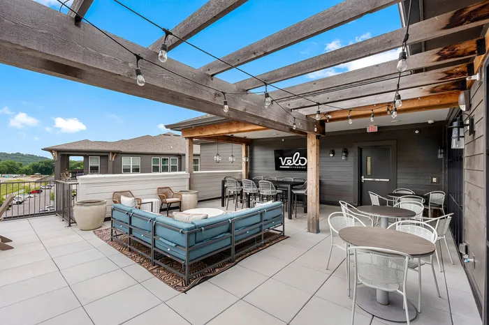 Chic outdoor patio with contemporary furniture, pergola, and stunning views at Velo Riverside.