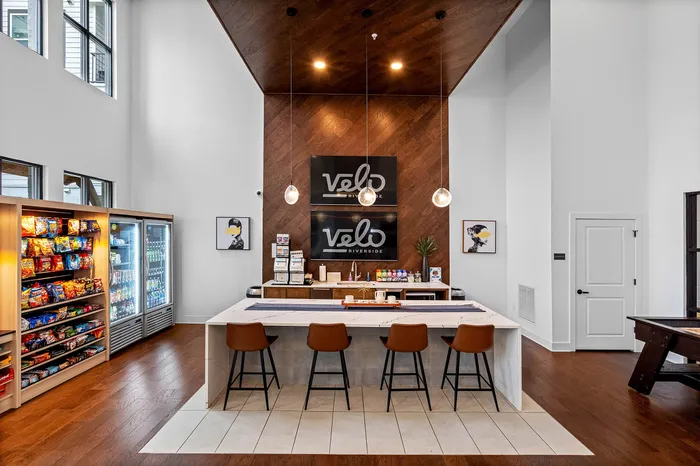 Chic communal space featuring a stylish snack bar with contemporary seating, vibrant wood accents, and modern decor, perfect for social gatherings.
