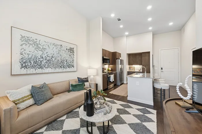 Contemporary open-concept living space featuring a chic living room with stylish decor and a modern kitchen with a sleek island.