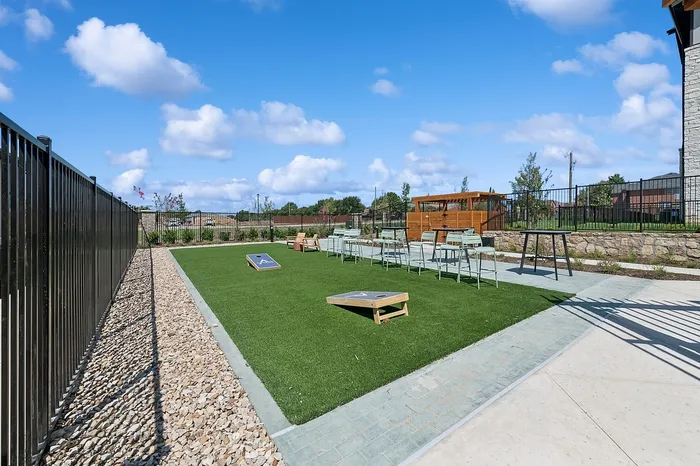 Inviting outdoor recreation area with vibrant green lawn and modern seating, perfect for entertaining or relaxation under the blue sky.